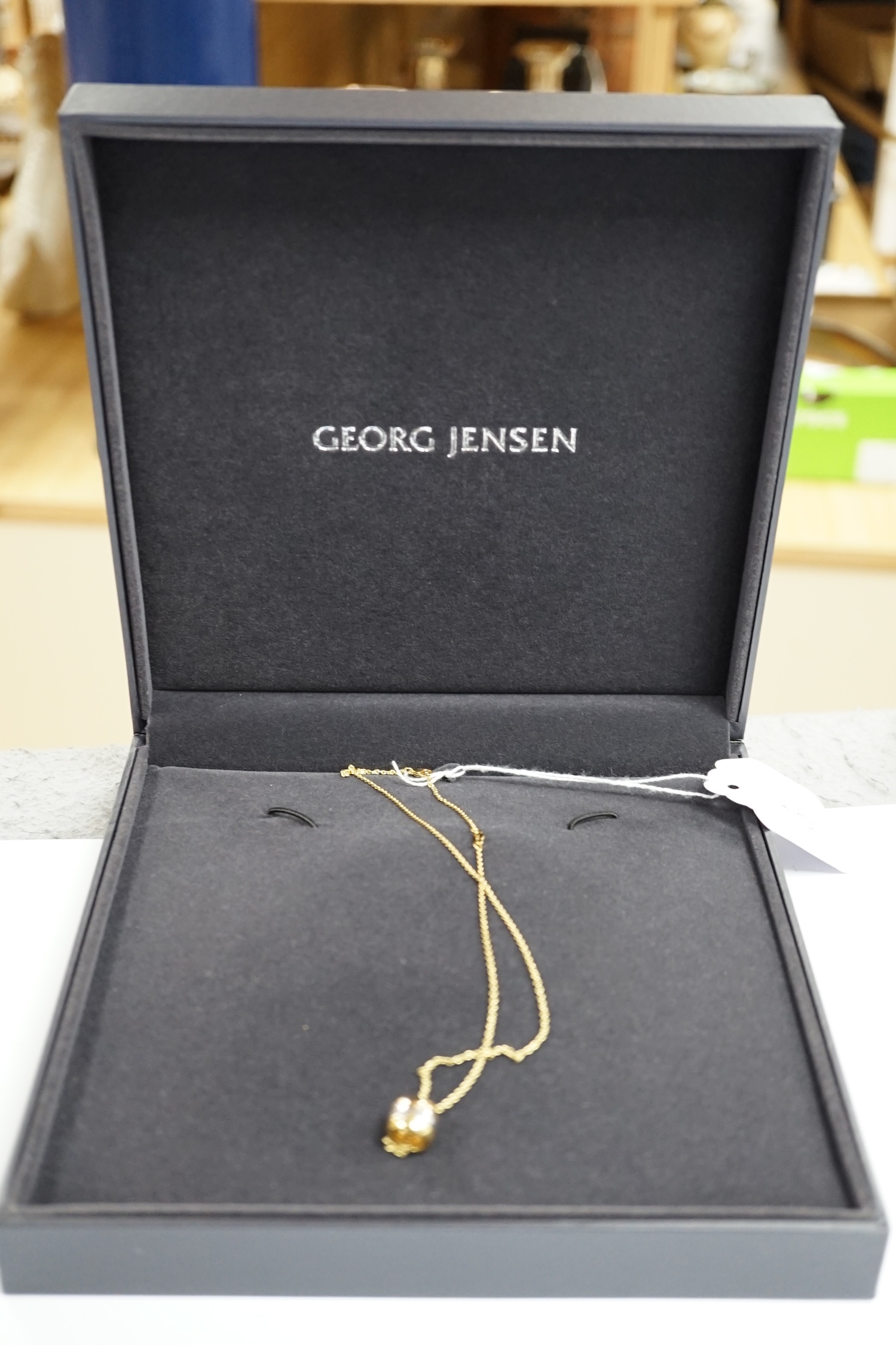 A modern Georg Jensen two colour 18ct gold barrel pendant, 10mm, on a Georg Jensen 18ct gold fine link chain, 42cm, gross weight 10.3 grams.